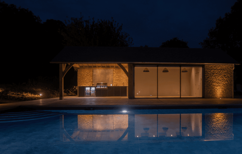 Outdoor kitchen by a pool at night